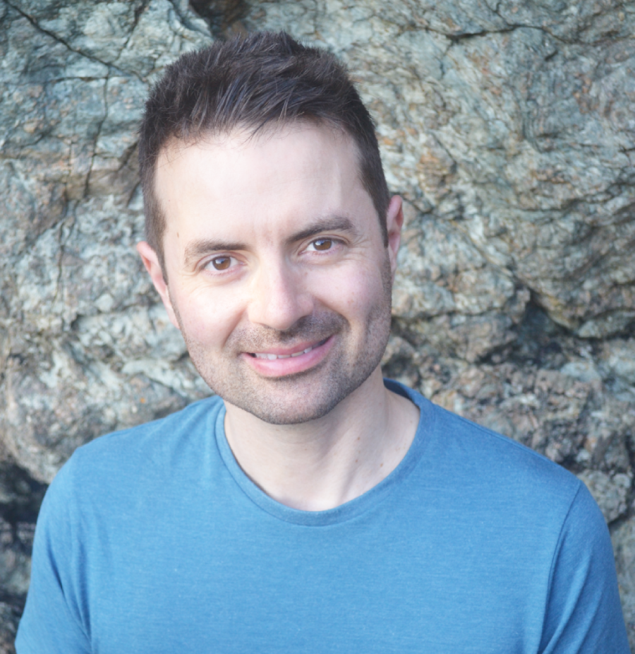 A man with dark hair and dark stubble